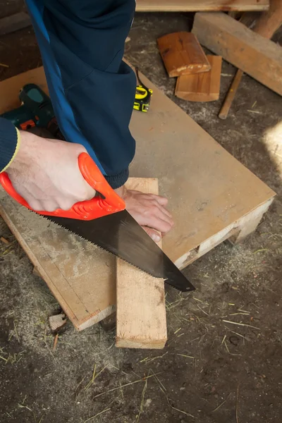 worker with Hand saw and wood plank