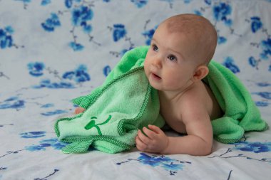 Duştan sonra havluya sarılmış küçük bir çocuk.