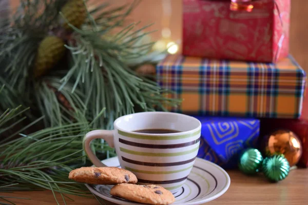 Christmas gifts and a cup of coffee in the foreground — Stock Photo, Image