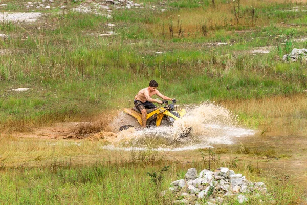 Off road on quad bike rally over mud puddle — Stock Photo, Image