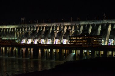 Foz do Iguazu, Brazil - july 10, 2016: View of the illuminated Itaipu dam giant barrage at night. The Dam is located on river Parana on the border of Brazil and Paraguay clipart