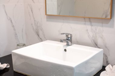 Aynalı ve mermer kaplamalı modern lavabo, temiz banyo iç tasarımı ve zarif tasarımı sergileniyor.