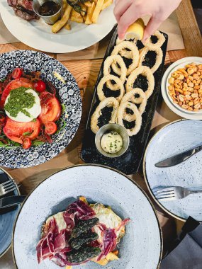 Tipik İspanyol yemekleri ile harika çeşitlilikte yemekler. Tabaklar: Serrano jambonlu omlet, patates ve biber; mozzarellalı domates salatası; çırpılmış ve kızarmış kalamar halkaları ve aioli ile kızarmış patates;.