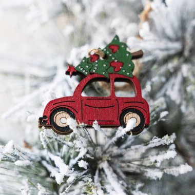 Yapay bir ağacın dalına klemple asılmış bir figür. Küçük figür, Noel ağacı olan ahşap bir Noel arabası. Arabanın tepesi. Beyaz rengeyiği çizilmiş kırmızı bir kurdele ağacı sarar..