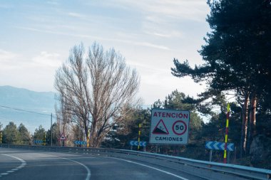 Trafik işaretleri, kamyonlar için hız limiti olan dik bir iniş mesafesini gösteriyor. İşaret, karların yüksekliğini ölçmek için kırmızı ve sarı işaretlerin de bulunduğu keskin bir eğriyi gösteren birkaç işaretten sonra geldi.