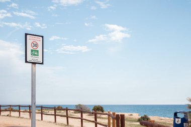 Alcocebre plajında (Castelln de la Plana) bisikletlerin tercihleri nedeniyle hız limitini aşmayın diye bir uyarı işareti vardır. Mavi bir ufuk ile bazı ahşap sınırlayıcı çitler görebilirsiniz. 