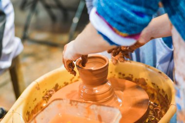 Çömlek çarkında kil şekillendiren eller