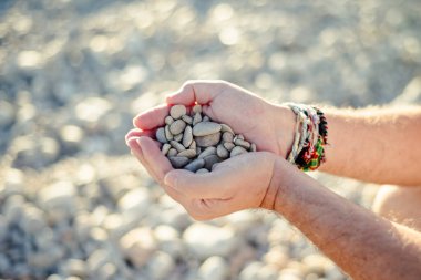 Bir avuç taşla bir erkek eli