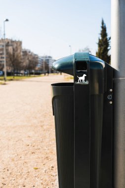 Köpek dışkısı torbaları, alanı köpek pisliğinden korumak için parkın her tarafına konan çöp kutularından alınabilir. Köpek şeklinde beyaz bir çizimle tanımlandı..