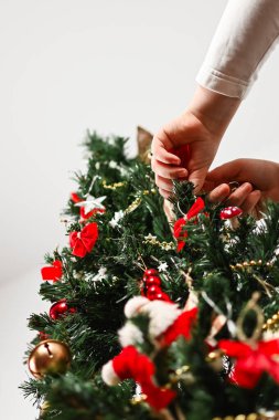 İki el Noel ağacına dekoratif süsler takar. Fotoğrafçı, fotoğrafı yerden, yerden çeker..
