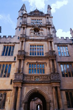 Oxford 'da geleneksel İngiliz Gotik mimarisini gösteren tarihi bir üniversite kulesinin dikey görüntüsü. Oxford, Birleşik Krallık, Eylül 2025.