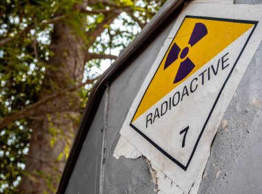 Radyasyon taşıma etiketi sınıf 7 etiketi alüminyum kamyon konteynırındaki eski çıkartmaya yapıştırılmış.