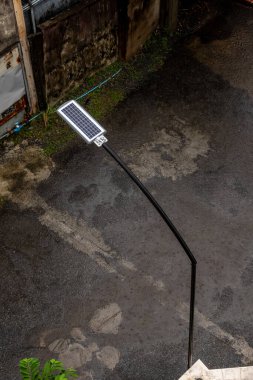 Yağmur küçük bir sokak lambasının arkasındaki küçük bir güneş paneline yağar.