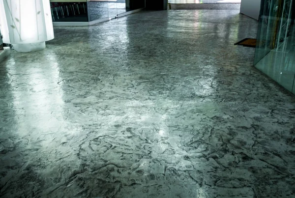 Binanın zemininde beton döşeme, cilalanmış ve cilalanmış yüzey dokusu var.