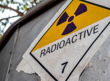 Radyasyon taşıma etiketi sınıf 7 etiketi alüminyum kamyon konteynırındaki eski çıkartmaya yapıştırılmış.