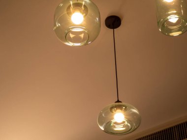 Temiz camdan yapılmış farklı seviyedeki tavan lambaları.