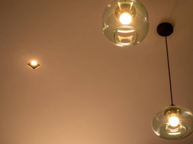 Temiz camdan yapılmış farklı seviyedeki tavan lambaları.