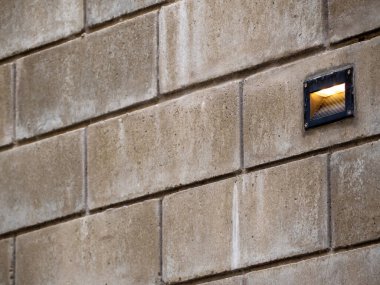 Tuğla duvarda, tavan arası süslemesi olarak açık hava lambası var.