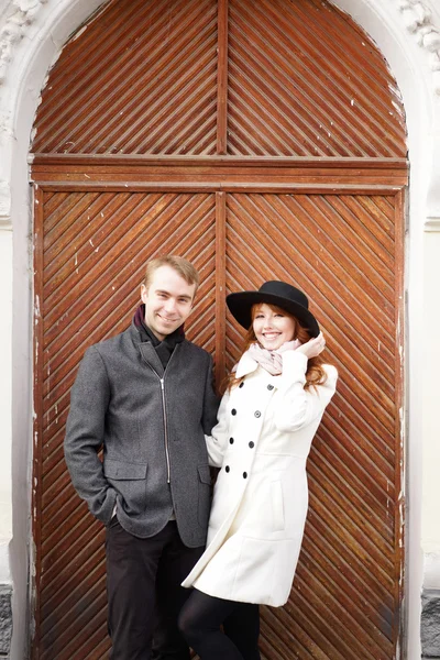 Belo casal sorridente contra de portas de madeira — Fotografia de Stock