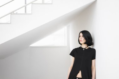 Genç kadın uzağa merdiven altında dururken arıyor