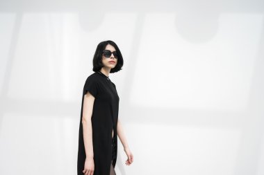 Yürüyen siyah saçlı kadın güneş gözlüğü