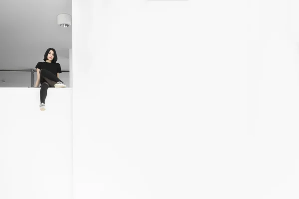 블랙 화이트 벽 근처에 앉아 있는 여자 — 스톡 사진