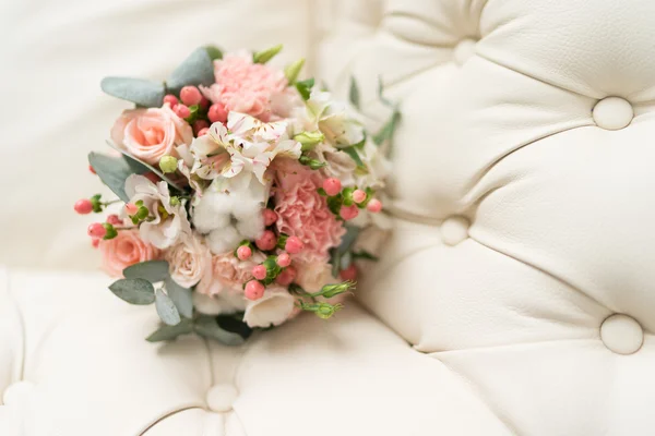 Букет невесты на кожаном диване — стоковое фото