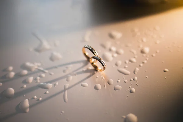 两个漂亮的结婚戒指，湿背景 — 图库照片