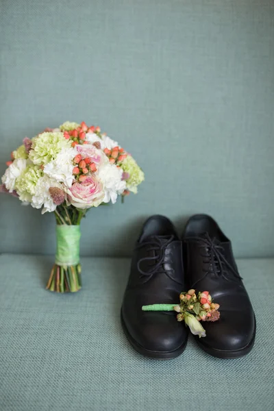 Bruidegom zwarte schoenen met bruids boeket — Stockfoto