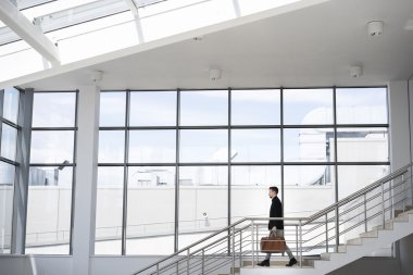 Adam basamaklardan iniyor çanta ile yan görünüm