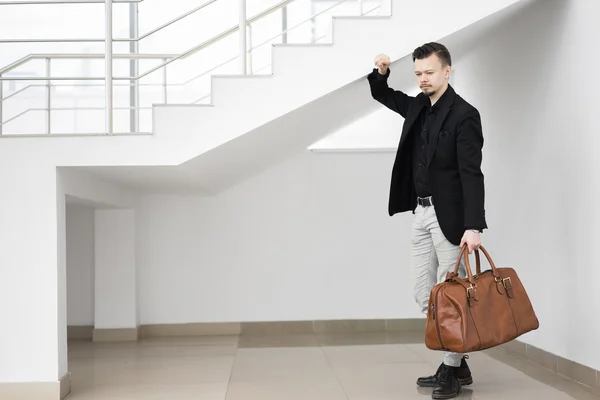 Ruhiger Mann mit Tasche posiert unter Stufen lizenzfreie Stockfotos