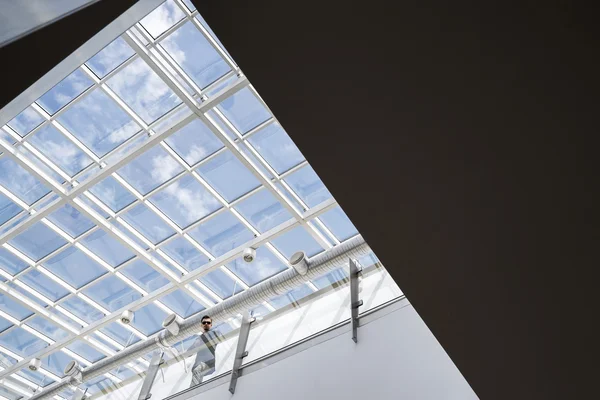 Человек на балконе против прозрачного потолка Стоковое Фото