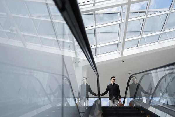 Бизнесмен смотрит в сторону, стоя на эскалаторе Стоковое Изображение