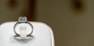 Bulanık arkaplanı olan beyaz bir kutunun üzerindeki zarif elmas yüzüğü kapat. yumuşak ve seçici odaklanma. Aşk ve düğün kavramı.