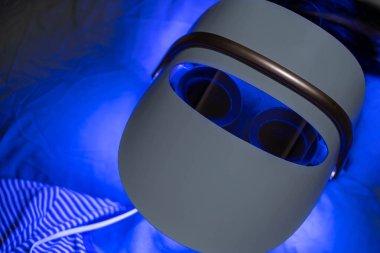 Mavi öncü ışık terapisi gören kadın yüz ve boyun maskesi foton terapisi.