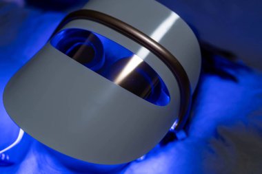 Mavi öncü ışık terapisi gören kadın yüz ve boyun maskesi foton terapisi.