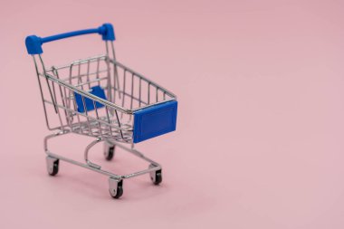 Pembe arka planda izole edilmiş alışveriş arabası. Mavi alışveriş arabası online alışveriş konsepti
