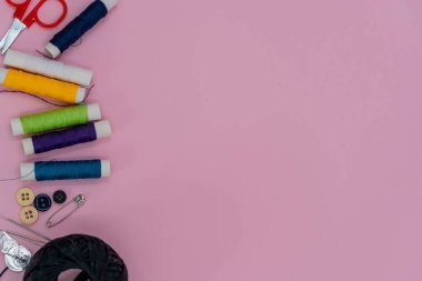 Dikiş arka planı. Ahşap arka planda dikiş işleri için aksesuarlar. İplik, makas, düğme, mezura, dikiş malzemeleri. Dikiş işi üst görünümü için ayarlandı