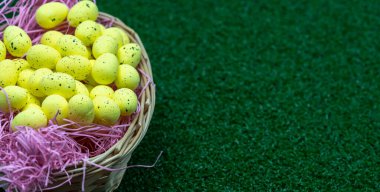 Çil desenli sarı Paskalya Yumurtası çimlerin üzerinde bir sepetin içinde