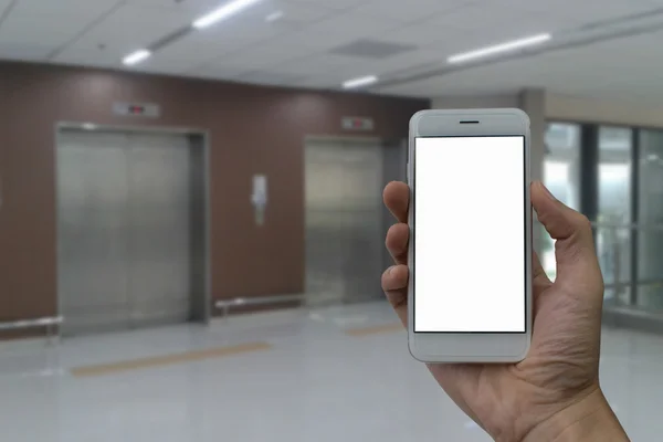 Um homem mão segurando tela vazia de telefone inteligente e elevador embaçado — Fotografia de Stock