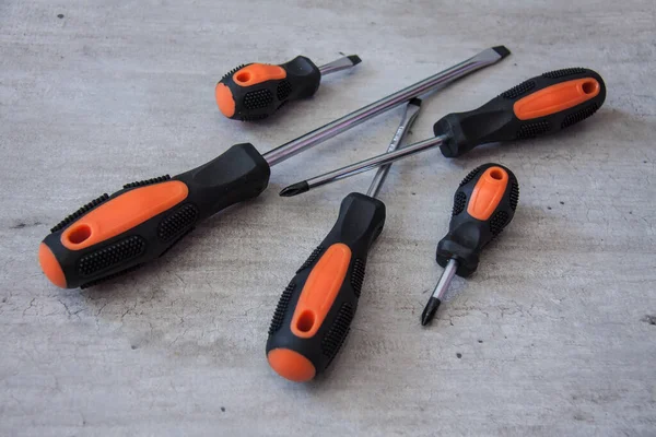 Metalowe śrubokręty i szczypce z czarnymi i pomarańczowymi uchwytami. — Zdjęcie stockowe
