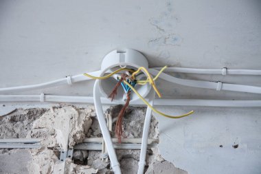 Elektrik kabloları, kablolar, alçılı bir duvarda..