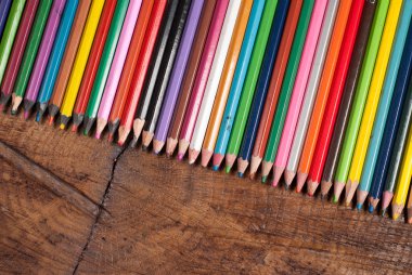 ahşap masa üzerinde renkli kalemler