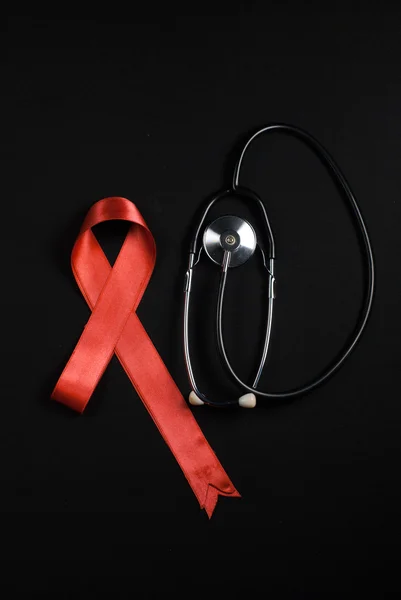 Stetoskop a červenou stužku, leží vedle sebe — Stock fotografie