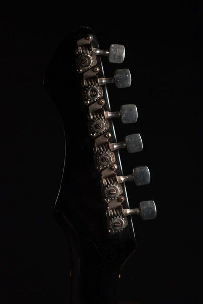 The mechanism of a tension of strings on the fingerboard of an old vintage electric guitar