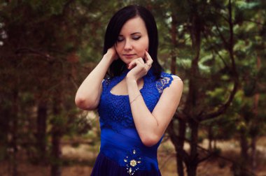 zarif mavi elbiseli koyu saçlı güzel genç kadın