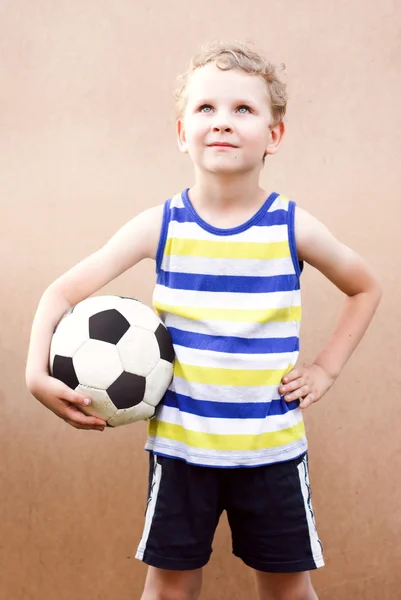 Küçük çocuk futbol topuyla standları, — Stok fotoğraf