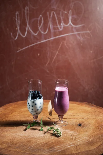 Batido de mirtilos, dois copos em uma mesa de madeira , — Fotografia de Stock