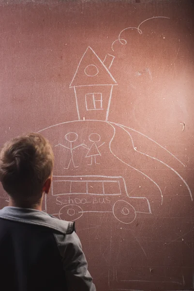 Мальчик рисует мелом на доске , — стоковое фото