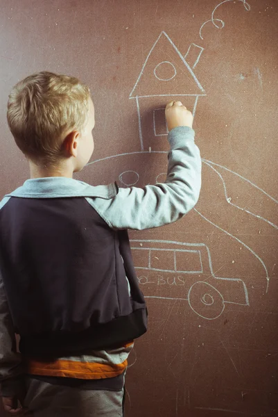 Little boy draws with chalk on a blackboard, — Stock Photo, Image